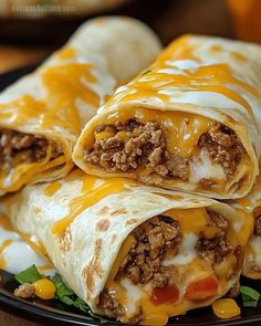 two burritos are stacked on top of each other with cheese and ground beef