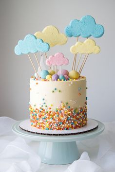 a cake with sprinkles and clouds on top