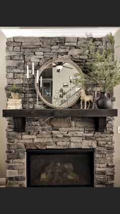 a stone fireplace with a mirror above it