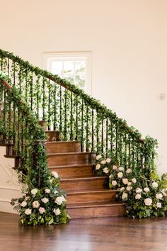 the stairs are decorated with flowers and greenery