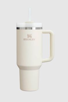 the white travel mug has a straw in it's cup handle and is shown