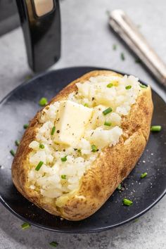 a baked potato on a plate with butter and chives