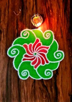 an intricately decorated diya on top of a wooden table next to a light