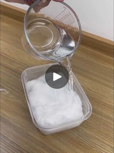 someone pouring sugar into a container on top of a wooden table