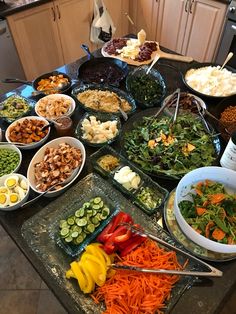 a table filled with lots of different types of food on top of plates and serving utensils