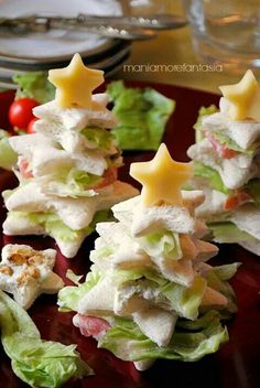 small sandwiches with cheese and lettuce are arranged in the shape of christmas trees