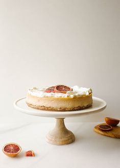 a cheesecake on a cake stand with blood oranges