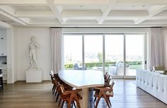 a dining room table with chairs and a statue in the background