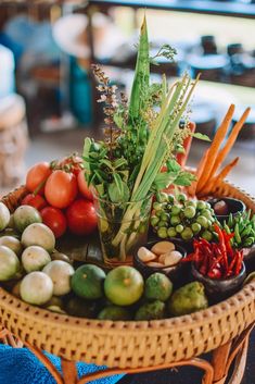 a basket filled with lots of different types of fruits and vegetables on top of a table