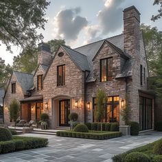 a large brick house with lots of windows and stone walkways leading to the front door