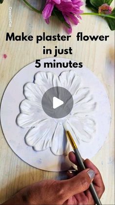 a person is making a flower out of paper and glues it with a paintbrush