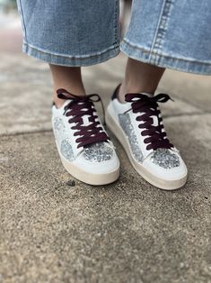 You will always be ready for Round Two in these trendy sneakers. The white and black sneakers feature a chic wine color shoelace with eye-catching silver sequins and star detailing. The pre-dirtied look adds a touch of edginess to these trendy sneakers. Perfect for those seeking a unique and stylish addition to their shoe collection. These also come with a hot pink pair of shoe laces . White And Black Sneakers, Heel Accessories, Round Two, Graphic Tee Dress, Wine Color, Trendy Sneakers, Be Ready, Wine Colored, Scarf Jewelry