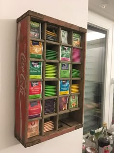 a wooden box filled with lots of food next to a wall mounted refrigerator freezer