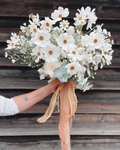 a person holding a bouquet of white flowers