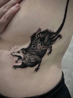 a woman's stomach with a rat tattoo on the side and an open mouth