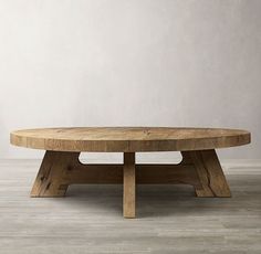 a wooden table sitting on top of a hard wood floor next to a white wall