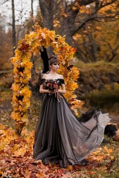 a woman in an off the shoulder dress is posing for a photo with leaves around her