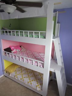 a white bunk bed sitting next to a purple wall