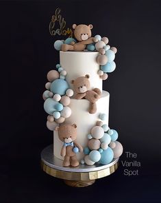 there is a three tiered cake with teddy bears on the top and balloons around it