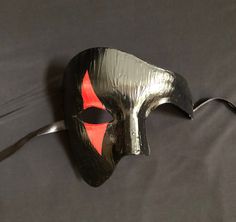 This Phantom Joker mask is hand painted and has raised detail. Mask is light weight and has a comfortable fit.  Stand out at your next Masquerade party with this unique mask.  Size 6"W x 5-1/2"H Red And Black Masquerade Mask Men, Black Phantom Mask, Full Face Red Mask For Cosplay, Red Horror Mask, Joker Mask, Mens Masquerade Mask, Unique Masks, Mask Black, Costume Mask