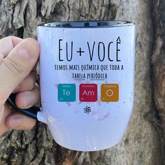 a person holding a coffee mug in front of a tree with the words eu - voce on it