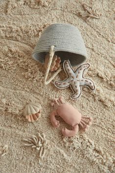 a hat, starfish and sea shells on the sand