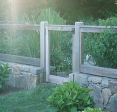 a garden with stone walls and green plants