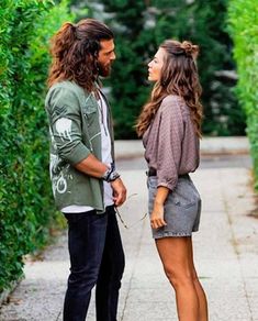 a man standing next to a woman on top of a sidewalk