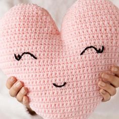 This super cute heart shaped pillow is beginner friendly and the perfect gift to show your love. The finished pillow measures 12 inches tall X 11.5 inches wide (at the widest part of the heart), which is the perfect size for snuggles! Add an optional face to your pillow to give her (or him) some personality. An added bonus: the pattern calls for bulky weight yarn, so you will work up this sweet pillow in no time. Materials: A size H (5 mm) Crochet Hook. Paintbox Yarns Simply Chunky yarn in: Ballet Pink (2 Skeins). Pure Black (optional if you are going to embroider face). Scissors. Tapestry/Yarn needle to sew up seams. Poly-Fil for stuffing pillow. Measurements: Skill Level: Beginner. 12 inches tall X 11.5 inches wide. Crochet Heart Pillow, Heart Shaped Pillow, Heart Cushion, Crochet Pillow Pattern, Heart Shaped Cookies, Shaped Pillow, Valentines Crochet, Baby Blanket Knitting Pattern, Haken Baby