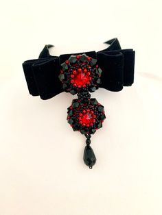 Add a touch of sophistication to your outfit with this exquisite Beaded Velvet Black Red Bow Bijou Jewelled Ribbon Choker. Handmade with love and attention to detail, this choker is crafted using a luxurious velvet black ribbon that gracefully hugs your neck. Adorned with a beautiful beaded ornament, this choker exudes elegance and delicate beauty. The intricate design of beads and ribbon is sure to turn heads and make a statement at any occasion. With a pendant height of 2.5 inches, it is sure Handmade Choker Necklace, Handmade Chokers, Black Velvet Choker, Bow Necklace, Velvet Choker, Beaded Ornaments, Teardrop Pendant, Choker Necklaces, Delicate Earrings