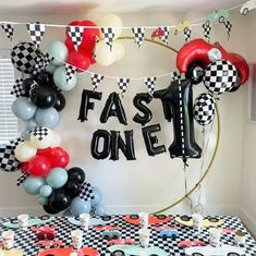 a table topped with lots of balloons next to a sign that says fast on jel