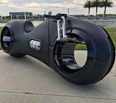 a large black object sitting on top of a cement floor next to a park area