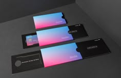 three black and pink business cards sitting next to each other on top of a table