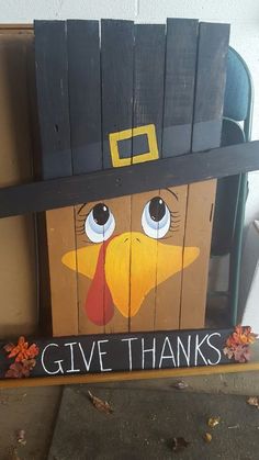 a wooden sign that says give thanks with a turkey wearing a pilgrim's hat