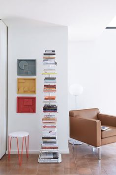 a room with a chair, table and bookshelf on the wall in front of it