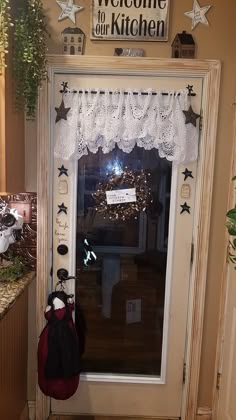 a welcome sign hangs on the front door of a home decorated with stars and lace