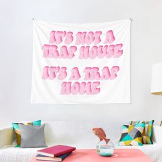 a pink and white wall hanging above a couch