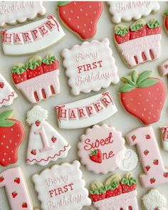 decorated cookies with the words happy first birthday and strawberrys on them are arranged in rows