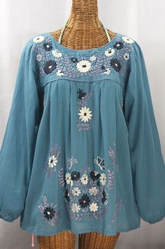 "* Ornate hand embroidery and elegant long sleeves with puff cuffs, available here in POOL BLUE with GREY MIX embroidery. * Light, gauzy and semi-sheer 100% cotton throughout; wear it billowy and flowing in the traditional bohemian style. * Entirely hand dyed, distressed and embroidered for an authentic, retro-vintage and hippie casual vibe. * Our ornate butterfly floral embroidery patterns are a faithful tribute to the original Mexican style hippie blouses of the 1970's. * Caringly embroidered Mexican Peasant Blouse, Embroidery Light, Hippie Blouse, Mexican Blouse, Pool Blue, Earthy Outfits, Floral Embroidery Patterns, Blouse Sleeveless, Mexican Style