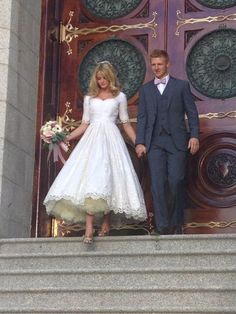 a man and woman are standing on the steps