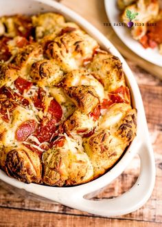 a casserole dish with cheese and pepperoni in it on a wooden table