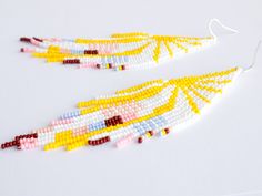 "Beaded fringe earrings with geometric pattern - yellow sun and pastel abstraction. These fashion pattern earrings made with glass Czech seed beads and unique modern design. They could be a great gift for wife, sister or girlfriend who love the unique style. Ready to ship. Color : white, yellow, brown, cornflower blue, light pink (see on pictures). Size: - width = 1.3 inches (34 mm), - length = 4.75 inches (120 mm) including ear wires. Materials: Czech seed beads, polyester-based silk thread, no White Tassel Earrings For Summer Festivals, Yellow Beaded Fringe Earrings For Festival, Handmade Yellow Tassel Earrings For Summer, White Fringe Beaded Earrings For Summer, White Beaded Fringe Earrings For Summer, Yellow Tassel Earrings For Summer Gift, Yellow Fringe Earrings For Summer, Yellow Fringe Earrings For Beach, Bohemian White Geometric Earrings