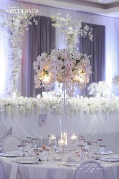 the centerpieces are filled with flowers and candles for an elegant touch to this wedding reception