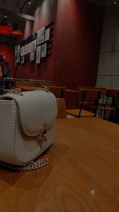 a white purse sitting on top of a wooden table