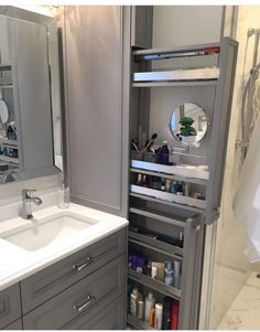 a bathroom with gray cabinets and white counter tops