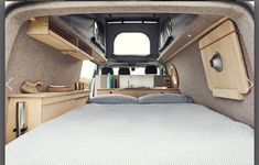 the interior of a camper van with its bed and desk in it's center