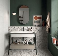 a white sink sitting under a bathroom mirror next to a wall mounted faucet