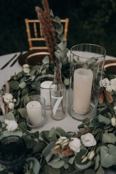 a table with candles and greenery on it