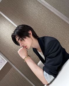 a woman sitting at a desk with her hand on her chin