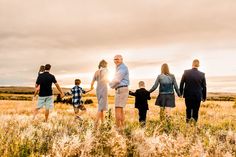 a group of people standing in a field holding hands